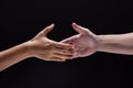 Closeup human hand ,between mand and woman.they are reaching to touch together,the sign and symbol of friendship