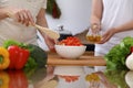 Closeup of human hands cooking in kitchen. Mother and daughter or two female friends mixing salad of vegetables. Healthy Royalty Free Stock Photo