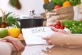 Closeup of human hands cooking in kitchen. Women discuss a menu. Healthy meal, vegetarian food and lifestyle concept