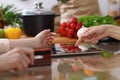 Closeup of human hands cooking in kitchen. Women discuss a menu using tablet computer. Copy space area at touch pad