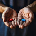 Closeup on human hands holding red and blue pill, tablet, health and medicine concept, choice, background Royalty Free Stock Photo