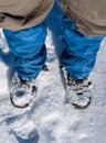 Closeup human traveler legs stay on a snow