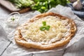 Closeup of a hungarian baked langos served with loevly cream, cheese, garlic and fresh green onion