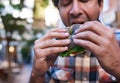 Hungry man sitting outside eating a delicious poppy seed bagel