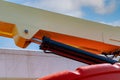 Closeup hydraulic of boom lift. Orange articulated boom lift. Maintenance and repair hydraulic boom lift service. Aerial platform