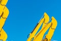 Closeup hydraulic piston of yellow backhoe against blue sky. Heavy machine for excavation in construction site. Hydraulic machine