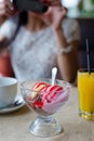 Closeup on ice cream in restaurant with female girl having fun holding mobile device taking selfie photo Royalty Free Stock Photo