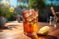 Closeup of ice lemon tea drink in glass and slice of lemon on table backlight backlit outdoors patio Royalty Free Stock Photo