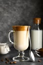 Closeup of Iced Dalgona coffee in glass mug on dark background. Trendy refreshment creamy whipped coffee. Korean coffee