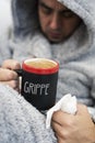 Ill man and mug with word grippe, flu in French