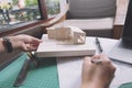 Closeup image of architects drawing shop drawing paper with architecture model Royalty Free Stock Photo