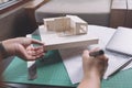 Closeup image of architects drawing shop drawing paper with architecture model Royalty Free Stock Photo
