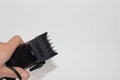 Closeup image of arm holding hairclipper, isolated on white background, an electric hair clipper in hand for hairdressers