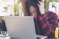 An Asian business woman with feeling stressed and tired , close her eyes while using laptop on glass table Royalty Free Stock Photo