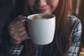 Closeup image of Asian woman smelling and drinking hot coffee with feeling good