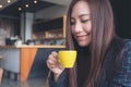 Closeup image of Asian woman smelling and drinking hot coffee with feeling good