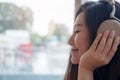 A beautiful Asian woman close her eyes and enjoy listening to music with headphone in modern cafe with feeling relax and happy Royalty Free Stock Photo