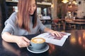 A beautiful asian woman reading magazine while drinking coffee in modern cafe Royalty Free Stock Photo