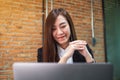 A beautiful businesswoman using earphone for video conference on laptop computer while working online Royalty Free Stock Photo