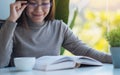 A beautiful young asian woman with eye glasses reading book Royalty Free Stock Photo