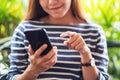 A beautiful young asian woman holding and using smart phone Royalty Free Stock Photo