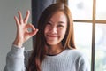 A beautiful young asian woman making and showing ok hand sign Royalty Free Stock Photo