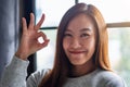 A beautiful young asian woman making and showing ok hand sign Royalty Free Stock Photo