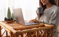 A beautiful young asian woman using and working on laptop computer while drinking coffee at home Royalty Free Stock Photo