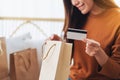 A beautiful young woman holding credit card while opening shopping bags at home Royalty Free Stock Photo