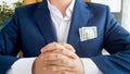 Closeup image of big stack of money showing from businessman`s jacket pocket