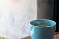 A blue mug of hot coffee on vintage wooden table in cafe Royalty Free Stock Photo