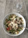 Closeup image of a bowl of tuna and bulgur wheat salad topped with shavings of Parmesan cheese