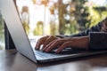 Closeup image of a business woman`s hands working , touching and typing on laptop keyboard