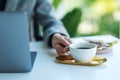 A business woman using and working on laptop computer while drinking coffee in office Royalty Free Stock Photo