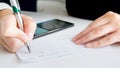 Closeup image of businesswoman writing amount of money on personal bank cheque Royalty Free Stock Photo