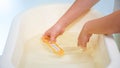 Closeup image of young caring mother filling baby bathtub and checking water temperature