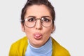 Closeup image of cheerful woman with hair knot sticking out her tongue having funny look isolated over white background Royalty Free Stock Photo