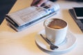 Closeup image of coffee cup , newspaper , laptop and smart phone on wooden table Royalty Free Stock Photo