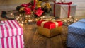 Closeup image of colorful gift boxes with ribbon on wooden floor under Christmas tree Royalty Free Stock Photo