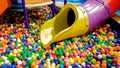 Closeup image of colorful slide on children playground with lots of small plastic ball in the pool. Royalty Free Stock Photo