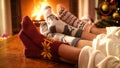 Closeup image of couple with child wearing knitted socks relaxing by the fire at house Royalty Free Stock Photo