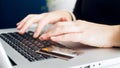 Closeup image of credit card lying on laptop keyboard while woman making online purchases Royalty Free Stock Photo