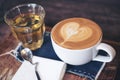 Closeup image of a cup of hot coffee and a tea glass on vintage wooden table Royalty Free Stock Photo