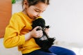 Closeup image of cute child playing at home with little dog. Pretty little girl with the puppy. Adorable kid hugging, playing with Royalty Free Stock Photo