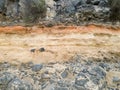 Closeup image of defferent layers of ground and stone on the mountain slope