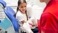 Closeup image of dentist educating her patient about tooth hygiene