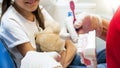 Closeup image of dentist teaching cleaning teeth using plastic teeth model