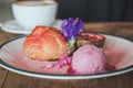 Closeup image of a dish of Choux cream , rose ice-cream and passion fruit with beautiful decoration and coffee cup