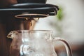 A drip coffee dropping into a beaker