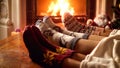 Closeup image of family in knitted woolen socks warming by fireplace Royalty Free Stock Photo